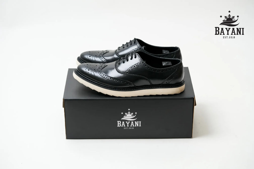 Black leather shoes on a black box with Bayani logo, on a white background

