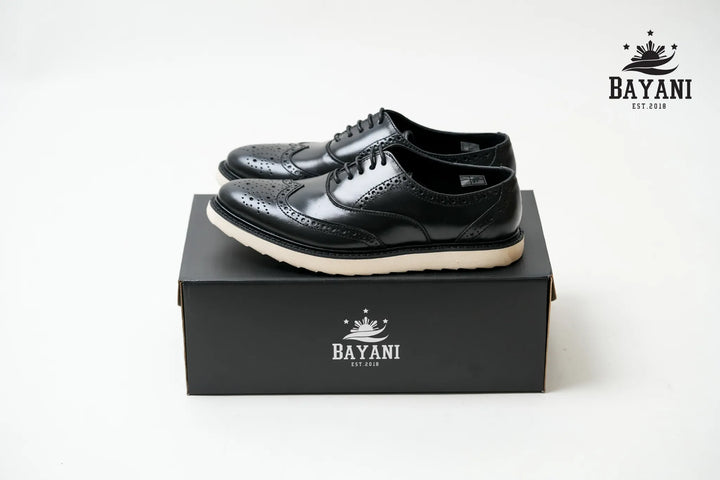 Black leather shoes on a black box with Bayani logo, on a white background
