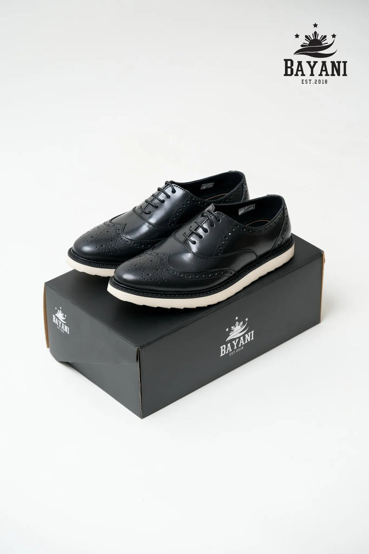 Black leather shoes on a black box with Bayani logo, on a white background
