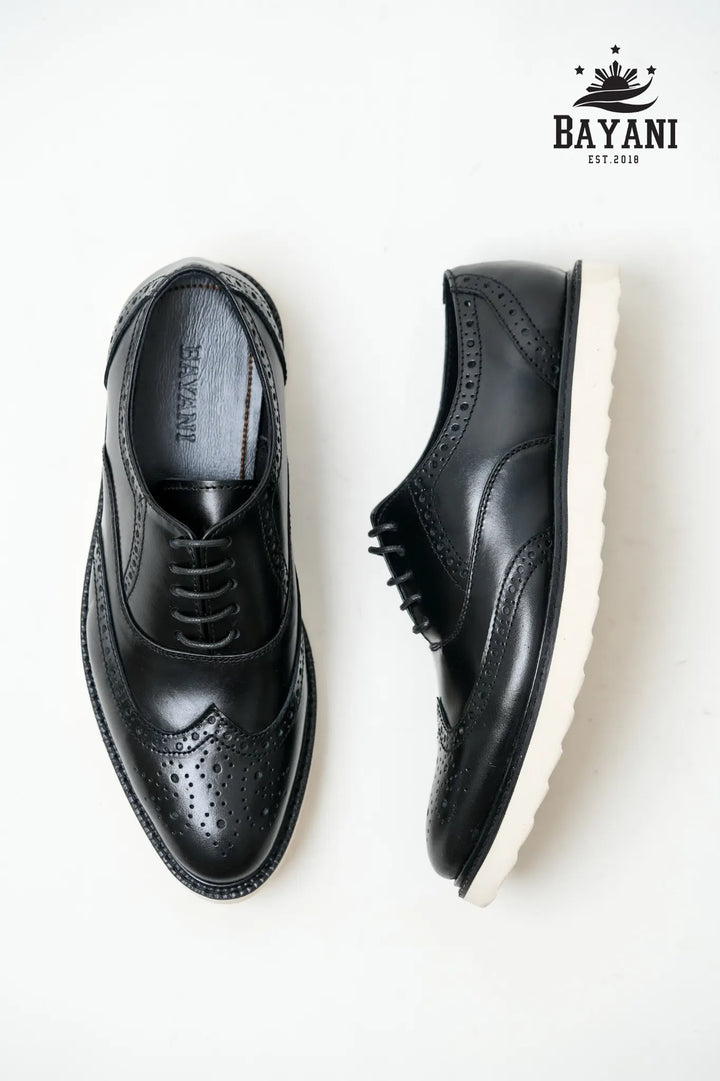 Black leather shoes on a white background with Bayani logo.

