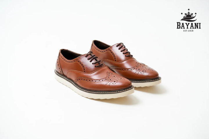 Pair of brown leather shoes with white soles on a light gray background, featuring the Bayani brand logo.
