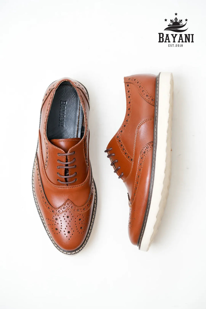 Pair of brown leather shoes on a white background with Bayani logo.
