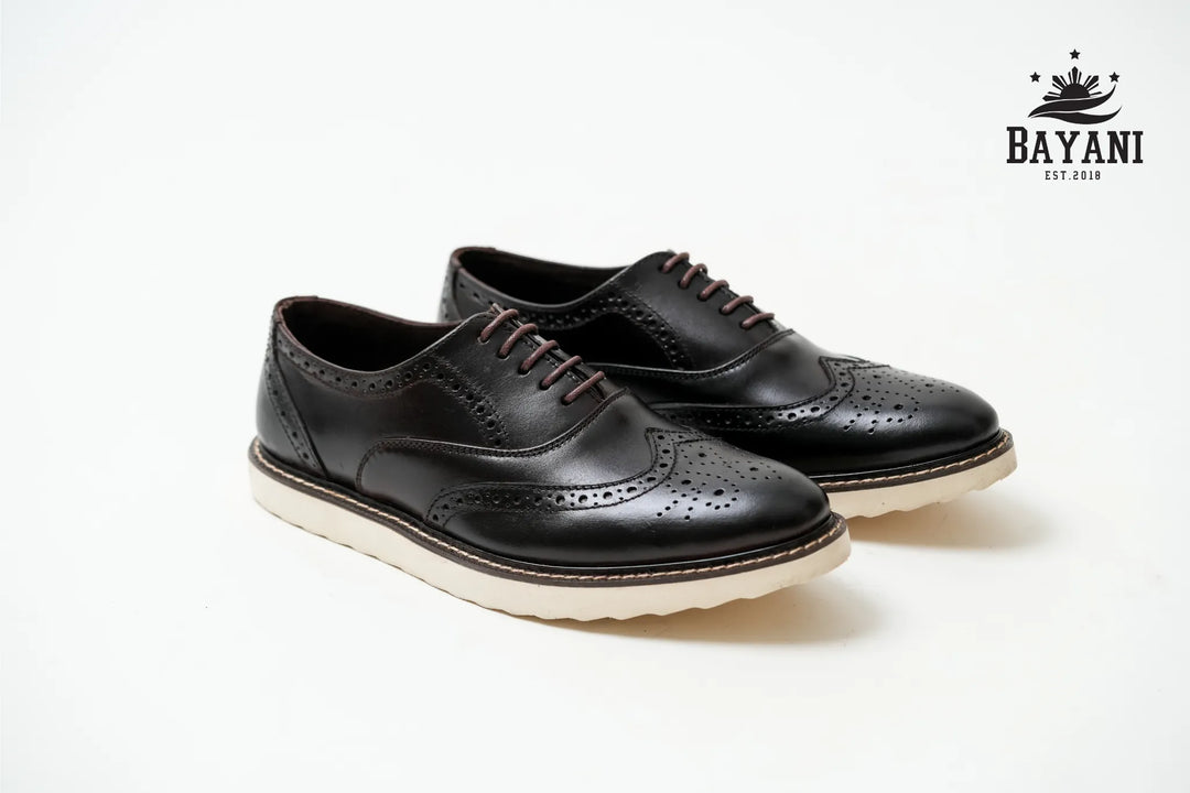 Black leather shoes with white soles on a white background, featuring the Bayani brand logo.
