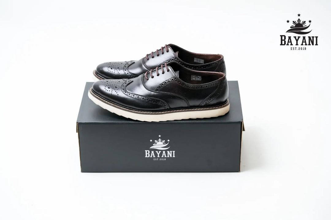 Black leather shoes on a black box with Bayani logo, on a white background

