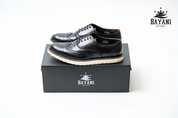 Black leather shoes on a black box with Bayani logo, on a white background
