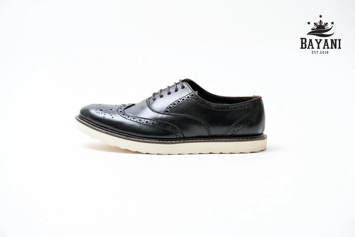 Black leather shoe with white sole on a light gray background, featuring the Bayani brand logo.
