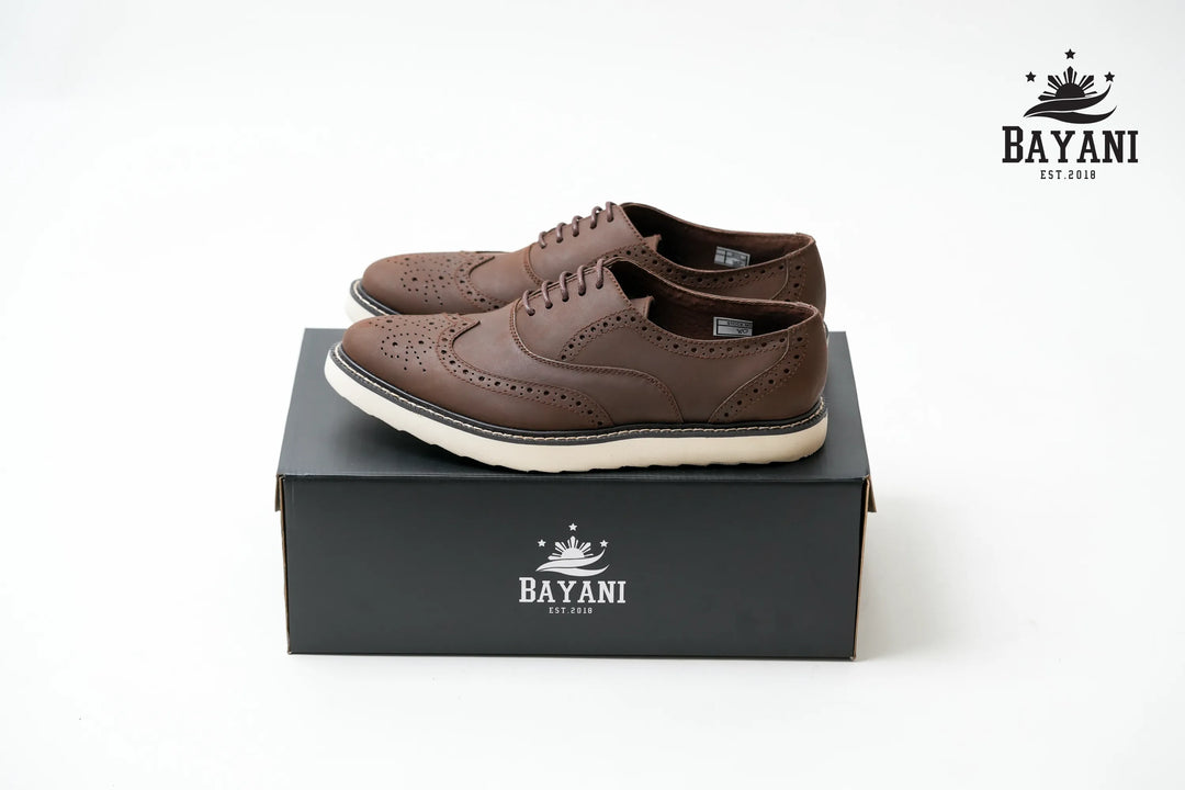 Brown shoes on a black box with Bayani logo on a white background

