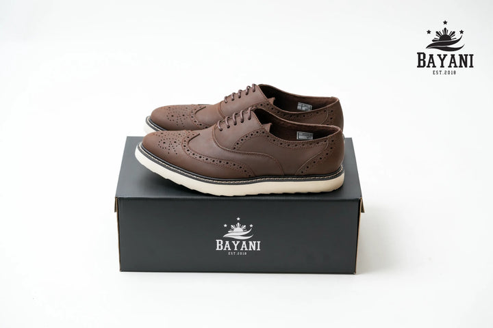 Brown shoes on a black box with Bayani logo on a white background

