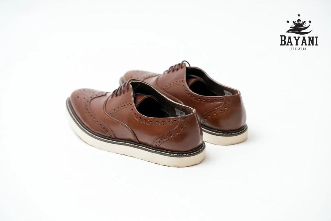 Brown leather shoes with white soles on a white background, featuring the Bayani brand logo.

