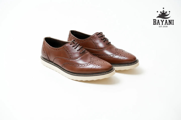 Brown leather shoes with white soles on a white background, featuring the Bayani brand logo.
