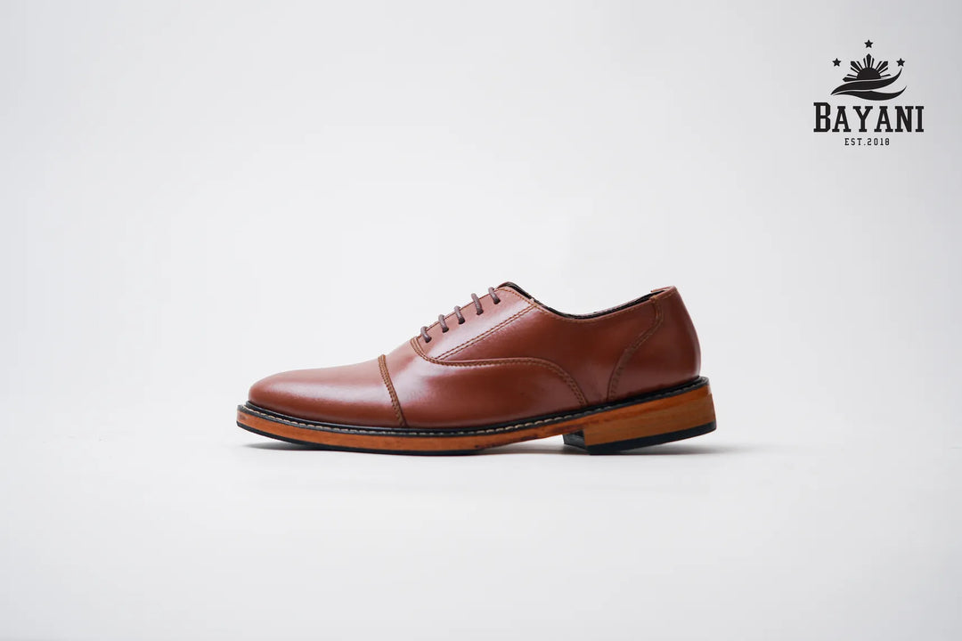 Brown leather shoe on a white background with Bayani logo.
