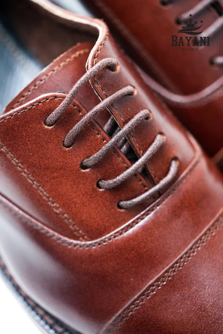 Close-up of brown leather shoes with &