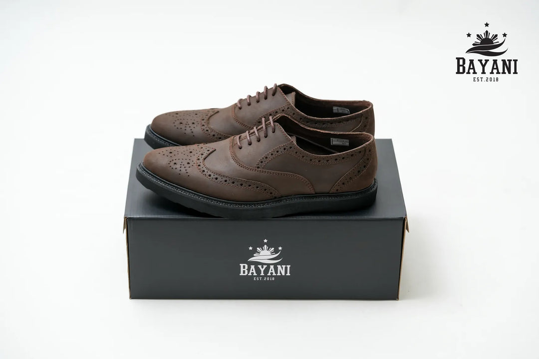 Brown leather shoes on a black box with Bayani logo on a white background

