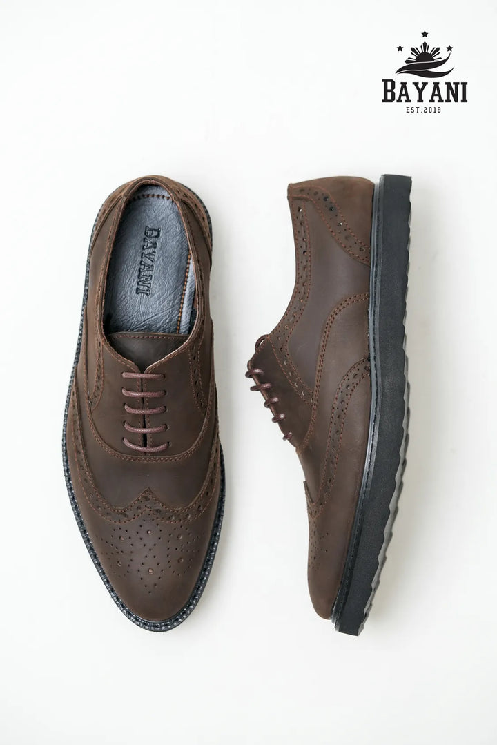 Brown leather shoes with black soles on a white background, featuring the Bayani brand.
