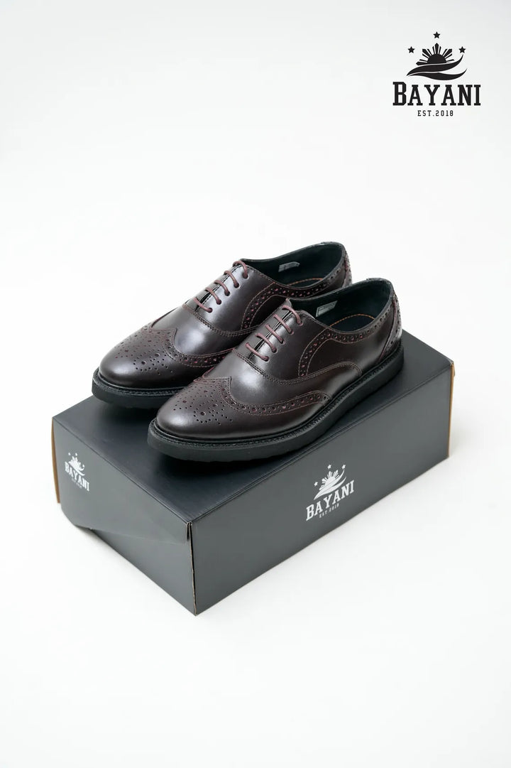 Brown leather shoes on a Bayani branded box with the Bayani logo above.
