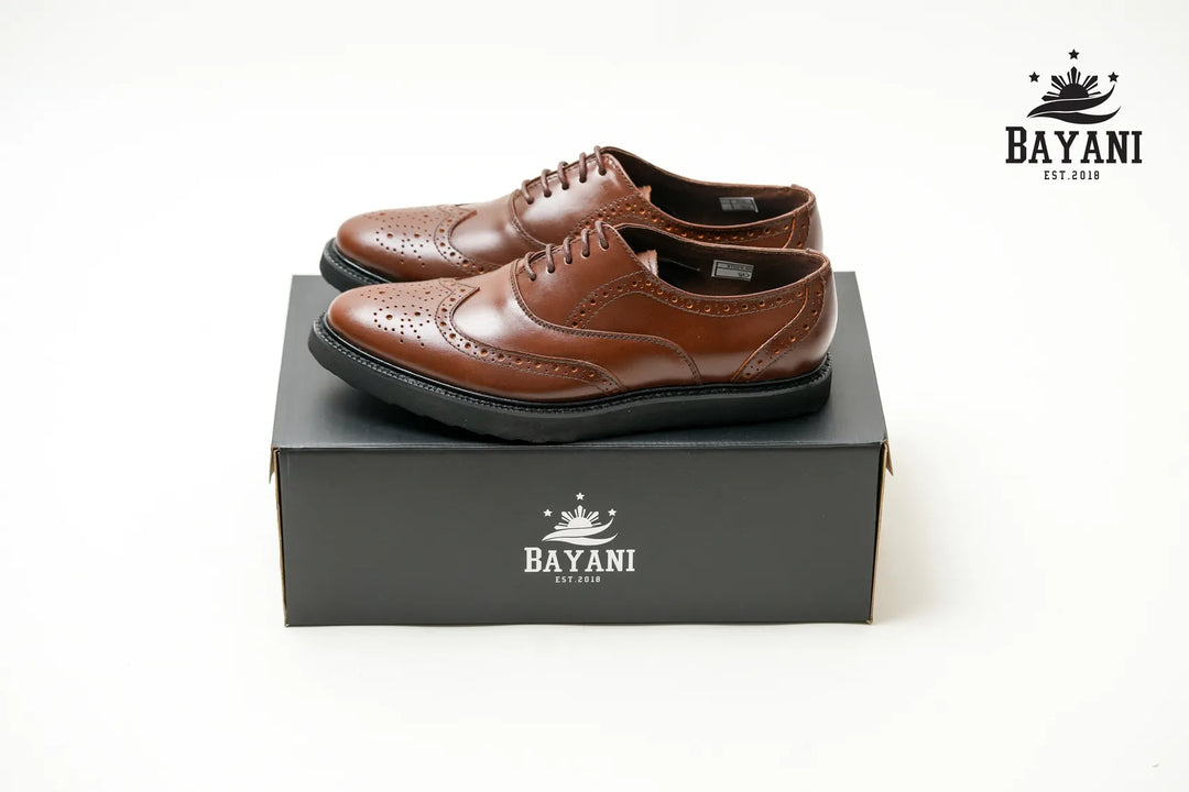 Brown leather shoes on a black box with Bayani logo

