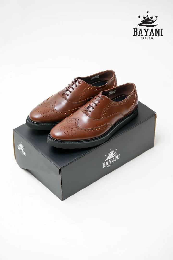 Brown dress shoes on a black Bayani box with the Bayani logo.
